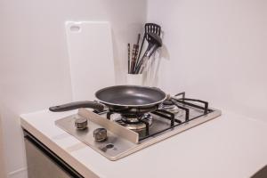 a frying pan sitting on top of a stove at Central Yoyogi Guesthouse Y0YG in Tokyo