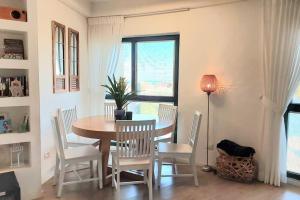 a dining room with a table and chairs and a window at Seaside Court Retreat By IsrApart in Tel Aviv