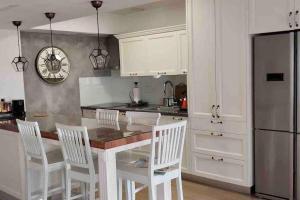 a kitchen with white cabinets and a table and chairs at Seaside Court Retreat By IsrApart in Tel Aviv
