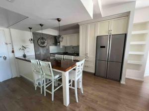 a kitchen with a table and chairs and a refrigerator at Seaside Court Retreat By IsrApart in Tel Aviv