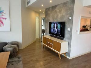 a living room with a flat screen tv on a cabinet at Seaside Court Retreat By IsrApart in Tel Aviv