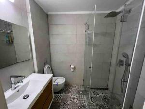 a bathroom with a shower and a sink and a toilet at Seaside Court Retreat By IsrApart in Tel Aviv