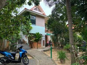 a blue scooter parked in front of a house at Sawasdee House in Lamai