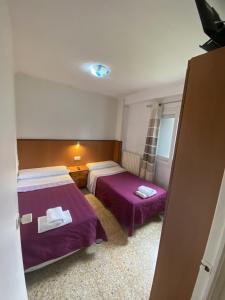 a bedroom with two beds with purple sheets at Casa Les Roques in Báscara +37 photos