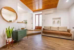 a living room with a couch and a mirror at Centro storico Sciacca - Casa Di Pisa in Sciacca
