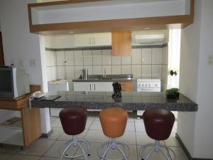 a kitchen with two bar stools and a counter at Green Valley Hotel in Acesita