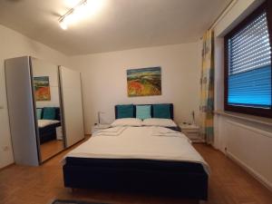 sypialnia z dużym łóżkiem i dużym oknem w obiekcie Appartment Cerny w mieście Eisenstadt