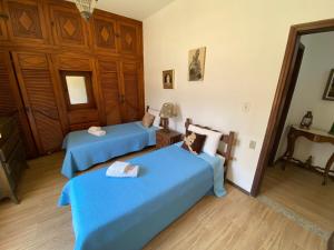 two beds in a room with blue sheets at Pousada Pe da Serra in Tiradentes