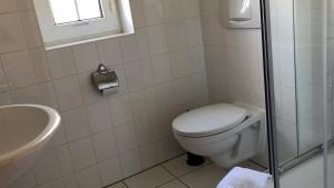 un bagno bianco con un water e un lavandino di -"Große Koje" Fewo im OG - Fischländer Weg 53A a Dierhagen