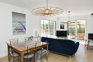un salon avec une table et un canapé bleu dans l'établissement St Gildas de Rhuys - Maison 10 personnes avec 5 chambres, 900 m plage et 500 m centre bourg, à Saint-Gildas-de-Rhuys