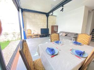 ein Esszimmer mit einem weißen Tisch mit blauen Servietten darauf in der Unterkunft Loft Bordeaux Près du Tram in Bordeaux
