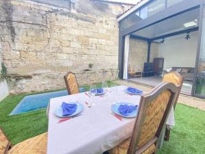 einen Tisch mit einer weißen Tischdecke und Stühlen sowie einem Tisch in der Unterkunft Loft Bordeaux Près du Tram in Bordeaux