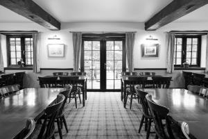 a dining room with tables and chairs and windows at Pack Horse Inn - New Mills in Mellor