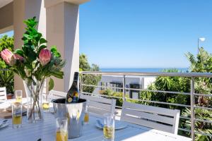 a table with a bottle of wine and flowers on a balcony at 100 Geneva in Cape Town