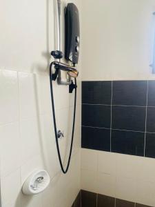 a shower in a bathroom with a phone on the wall at Batang kali Home stay on the Hill in Batang Kali