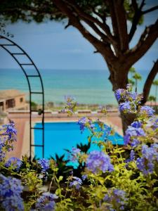 Un jardín con flores violetas y una piscina. en Home 120, Mansion Alhamar, en Sitio de Calahonda