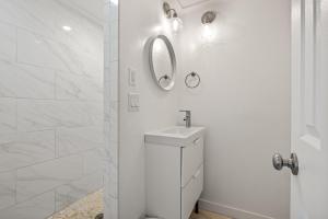 a white bathroom with a sink and a mirror at KDH187 Lunar Tide in Kill Devil Hills +28 photos