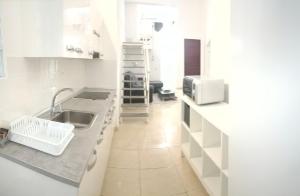 Una cocina blanca con fregadero y microondas. en CLARET LAS PALMAS DE GRAN CANARIA CITY, en Las Palmas de Gran Canaria 58 fotos más