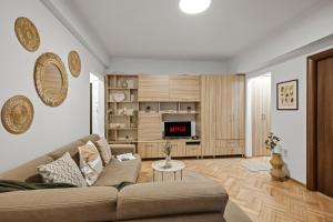 a living room with a couch and a tv at Earthy Escape - Central Apartment with Balcony in Bucharest