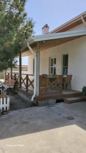 a house with a wooden porch with a table at Pine house in Gürgan