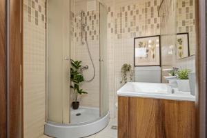 a bathroom with a sink and a shower at Earthy Escape - Central Apartment with Balcony in Bucharest