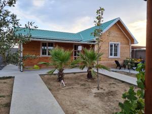 a wooden house with a green roof at Pine house in Gürgan