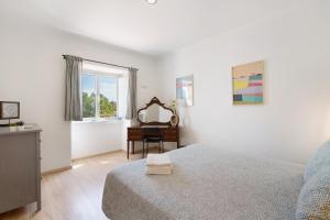 a bedroom with a bed and a desk and a mirror at Monte da Bisa - Tavira in Santo Estêvão