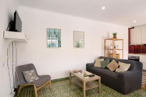 a living room with a couch and a table at Monte da Bisa - Tavira in Santo Estêvão