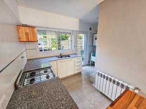 a kitchen with a sink and a stove top oven at Dúplex Familiar Av 5 y Paseo 117 in Villa Gesell