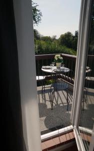 un patio con tavolo e sedie su un balcone di Ruhige Ferienwohnung mit Fernblick a Modautal