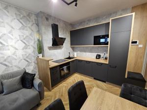 a kitchen with a couch and a table in a room at apartament mono loft in Ełk