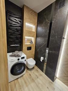 a bathroom with a washing machine and a toilet at apartament mono loft in Ełk