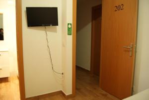 a room with a television on the wall and a door at Habitaciones El Escorial in Majadahonda