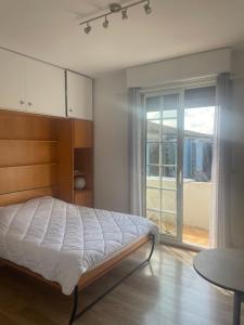 a bedroom with a bed and a sliding glass door at Studio lumineux au calme en centre ville, face aux thermes in Salies-de-Béarn
