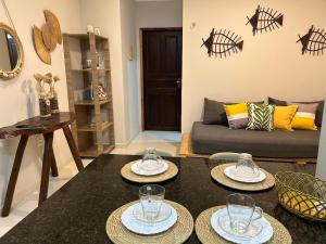 a living room with two tables and a couch at Studio pé na areia com 2 quartos, sala e cozinha in Trairi