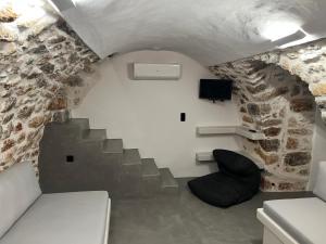 a small room with a staircase in a stone wall at Dome in Kharoúdha +26 photos