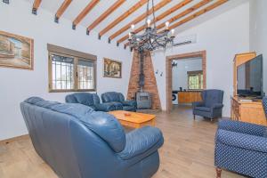 a living room with blue couches and a tv at Cortijo El Paraíso Granada in Atarfe