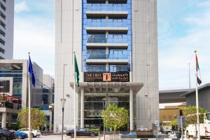 a tall building with a sign in front of it at The First Collection Dubai Marina in Dubai