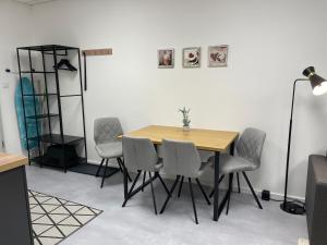 a dining room with a wooden table and chairs at SweetHome - Studio Apartment Ergolding in Ergolding