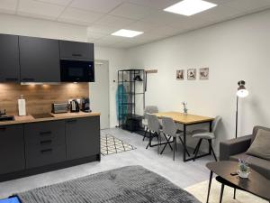 a living room with a kitchen and a table with chairs at SweetHome - Studio Apartment Ergolding in Ergolding