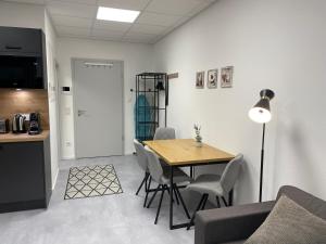 a living room with a table and chairs and a kitchen at SweetHome - Studio Apartment Ergolding in Ergolding +3 photos