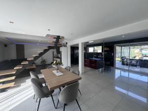 a dining room with a table and chairs and a staircase at Le QG des Bolides - 15 pers - Circuit - Rêve au Mans in Saint-Mars-dʼOutillé