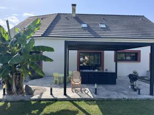 a house with a patio with a chair and a table at Le QG des Bolides - 15 pers - Circuit - Rêve au Mans in Saint-Mars-dʼOutillé