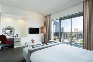 a hotel room with a bed and a large window at The First Collection Dubai Marina in Dubai