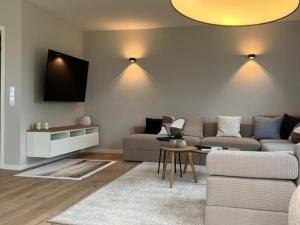 a living room with a couch and a tv at Ferienhaus Reethauszeit in Dranske