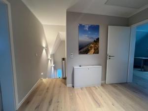 una sala de estar vacía con una foto en la pared en Ferienhaus Reethauszeit, en Dranske 15 fotos más