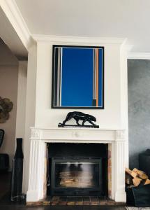 ein Kamin mit einer Hundestatue darauf in der Unterkunft Le 8 in Mutzig