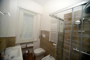 a bathroom with a toilet and a glass shower at Casa Parisina in Chianciano Terme