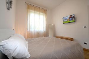 a bedroom with a large white bed and a window at Casa Parisina in Chianciano Terme