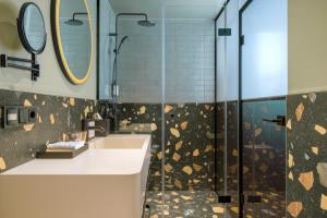 łazienka z prysznicem, umywalką i lustrem w obiekcie Mayburg Salzburg, a Tribute Portfolio Hotel w mieście Salzburg